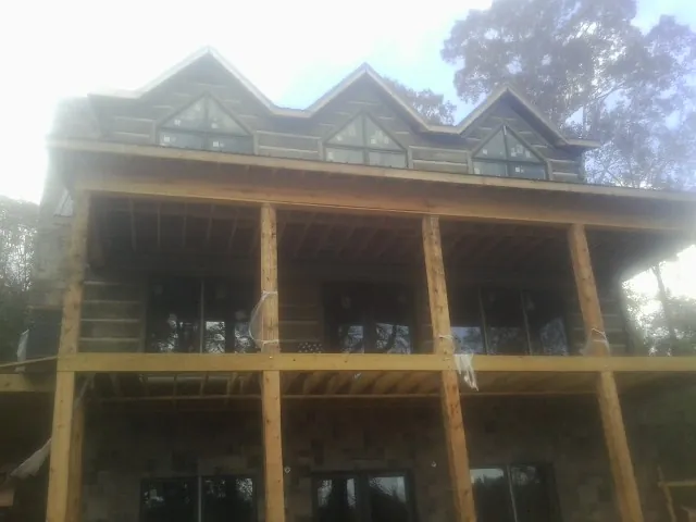 Dormers and porch framing on a large log home under construction — Roof Coating work by our crew in Red Boiling Springs